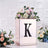 Floral arrangement in a decorative box with the letter "K" on a textured background.