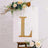 Gold marquee letter "L" decorated with flowers on an easel.