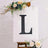 Decorative letter "L" on a white canvas with floral accents.