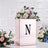 Rose gold floral arrangement box with letter "N" and decorative flowers.