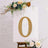 Gold marquee letter "O" on a decorated easel with flowers.