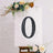 Decorative black number zero with floral accents on an easel.