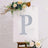 Decorative letter "P" with floral accents on an easel.