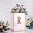 Rose gold floral arrangement box with letter 'R' and decorative flowers.