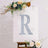 Decorative glitter letter "R" on a floral backdrop.