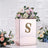 Rose gold floral arrangement box with letter S decoration.