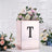 Rose gold floral arrangement box with initial "T" and decorative flowers.