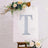 Glittery letter "T" on an easel with floral accents.