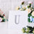 Silver rhinestone letter "U" on a white background.