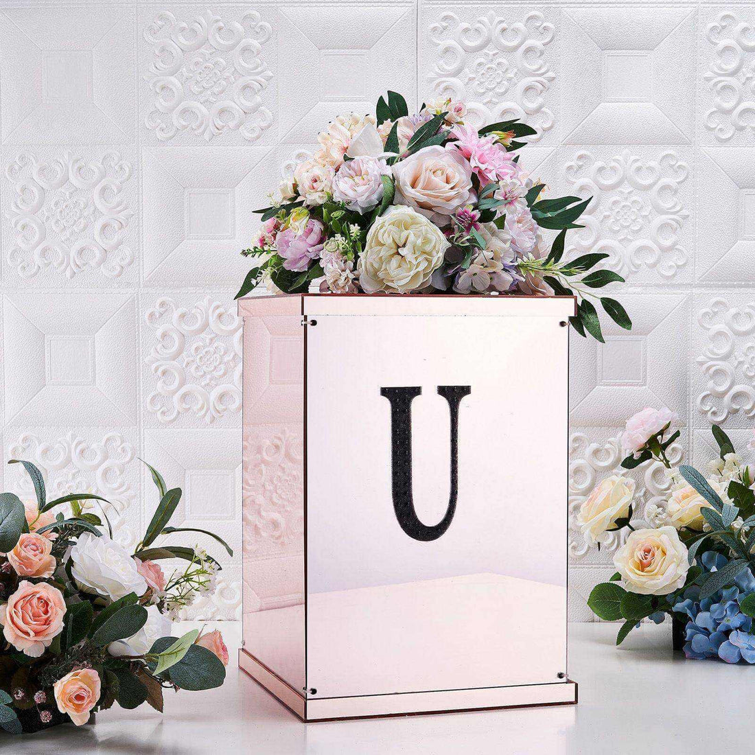 Rose gold flower box with floral arrangement and initial "U".