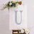 Decorative letter U with diamond accents on a white canvas with floral arrangement.