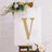 Gold studded letter V on a canvas with floral accents.