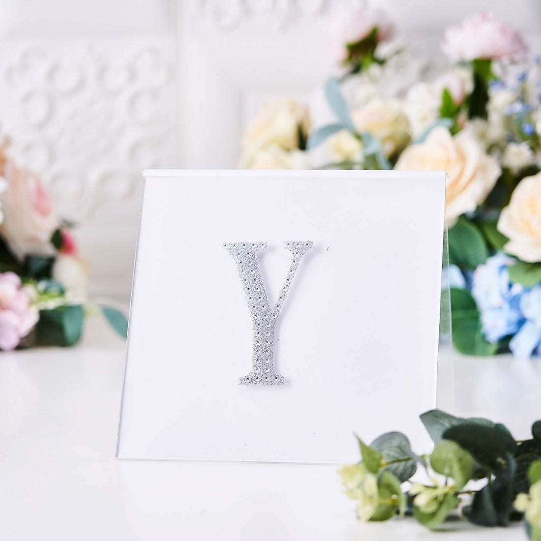 Silver decorative letter "Y" on a white background.