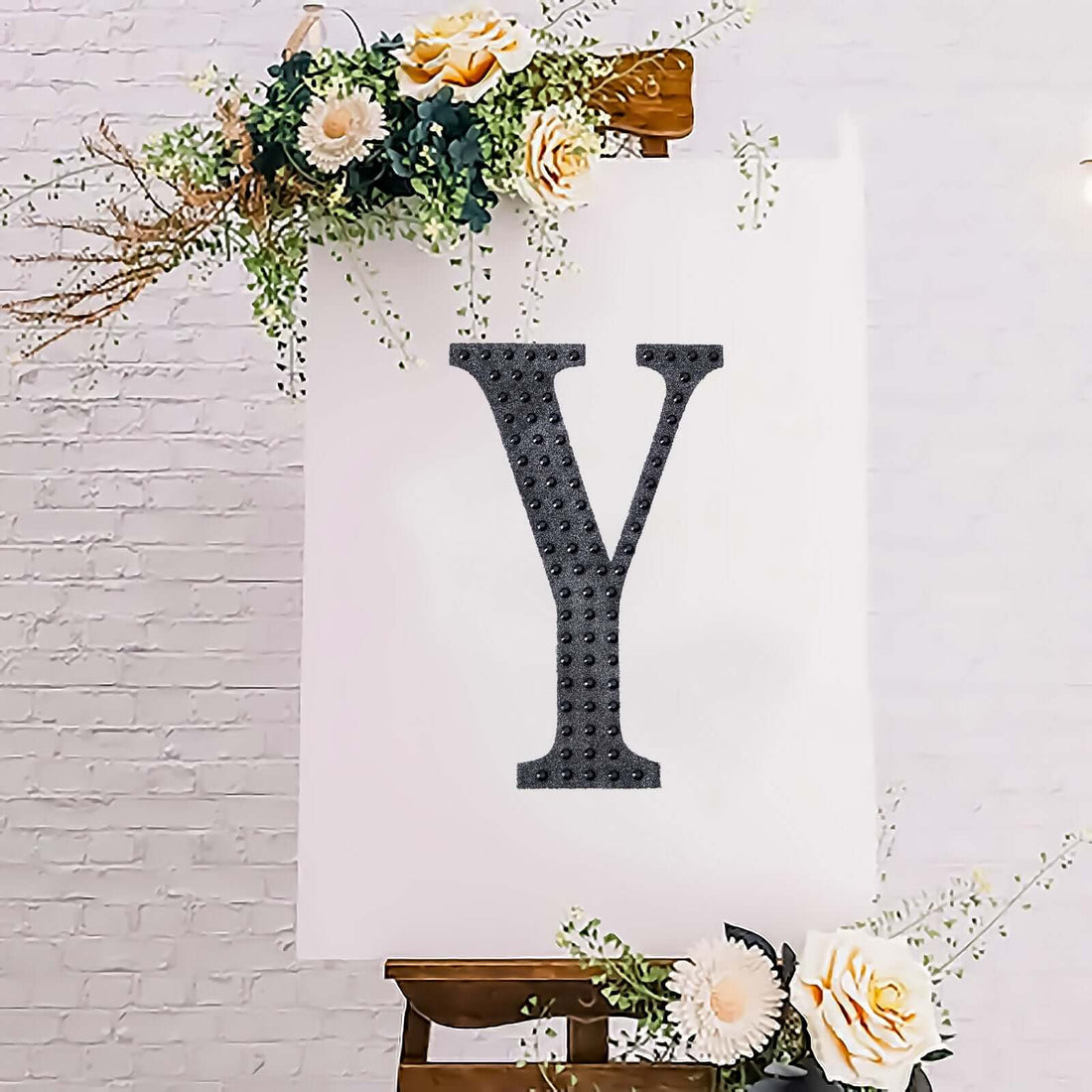 Decorative letter "Y" on an easel with floral accents.