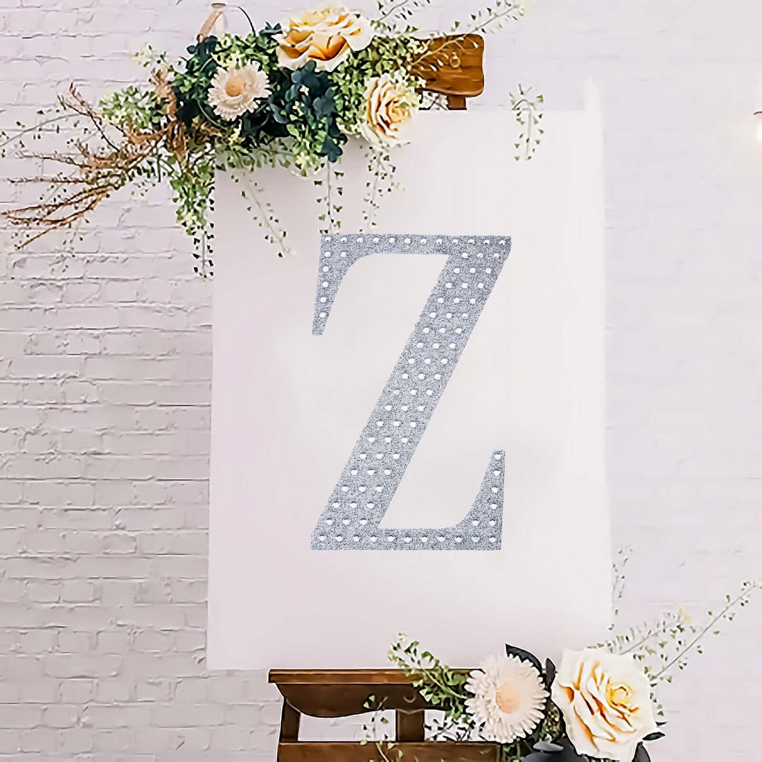 Decorative letter 'Z' on an easel with floral accents.