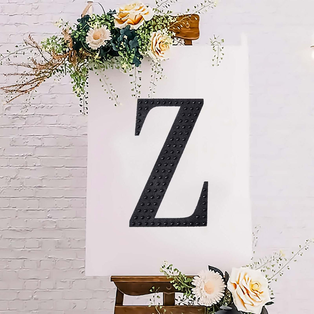 Decorative letter 'Z' displayed on an easel with floral accents.
