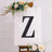 Decorative letter 'Z' displayed on an easel with floral accents.