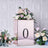 Rose gold floral arrangement box with number "0" on a textured background.