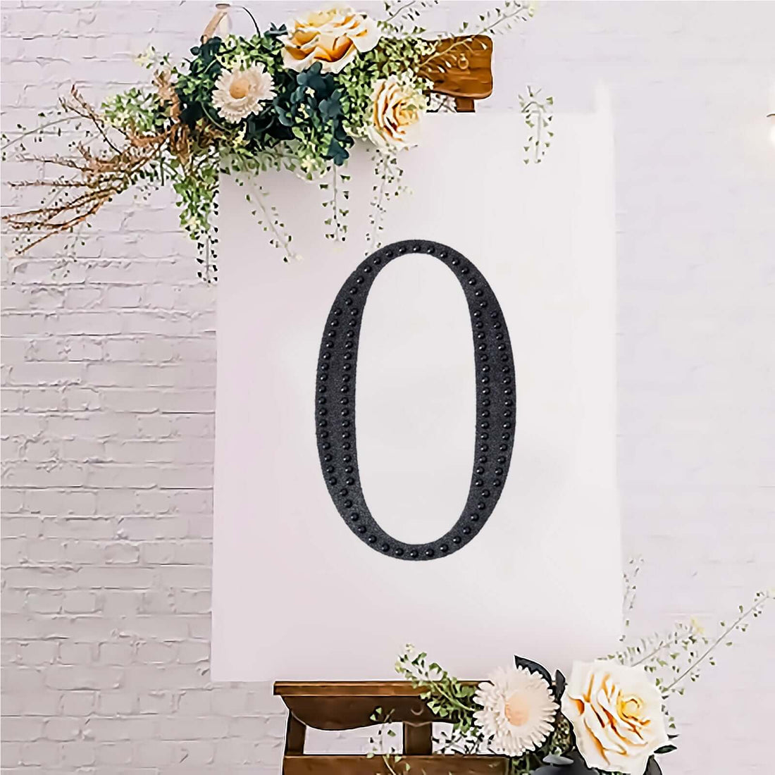 Decorative black number zero on a white canvas with floral accents.
