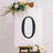 Decorative black number zero on a white canvas with floral accents.