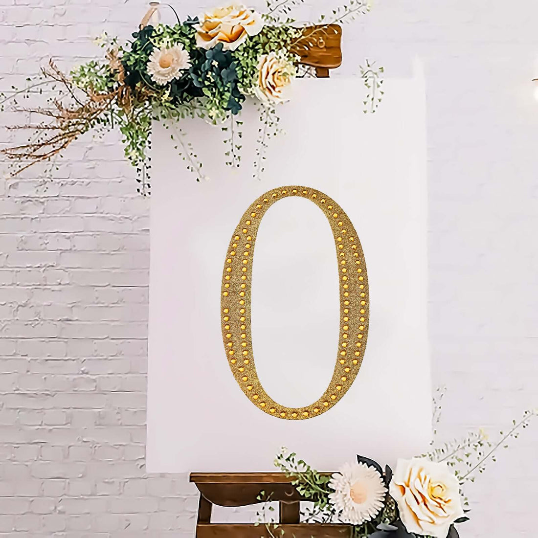 Gold decorative number zero on an easel with floral accents.