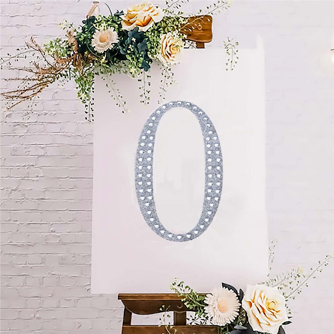 Decorative floral number "0" on a canvas with embellishments.