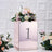 Rose gold flower box with number one and floral arrangement on textured background.