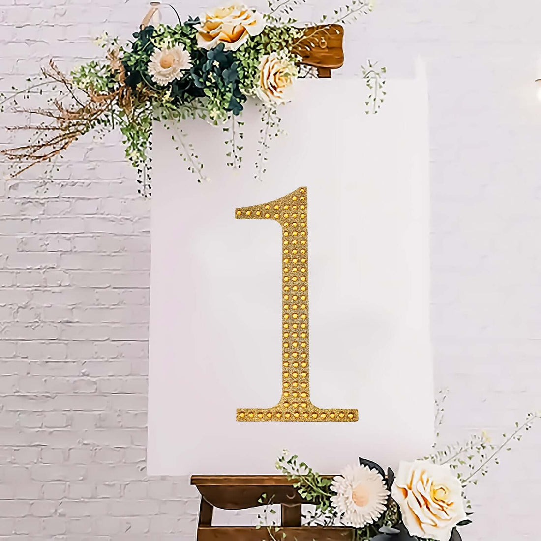 Gold rhinestone number one on a floral easel backdrop.