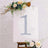 Decorative number one with floral accents on an easel.