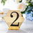 Gold hexagon table number sign with black rhinestones, featuring the number 2.