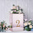 Rose gold square box with the number 2, adorned with flowers on a textured background.