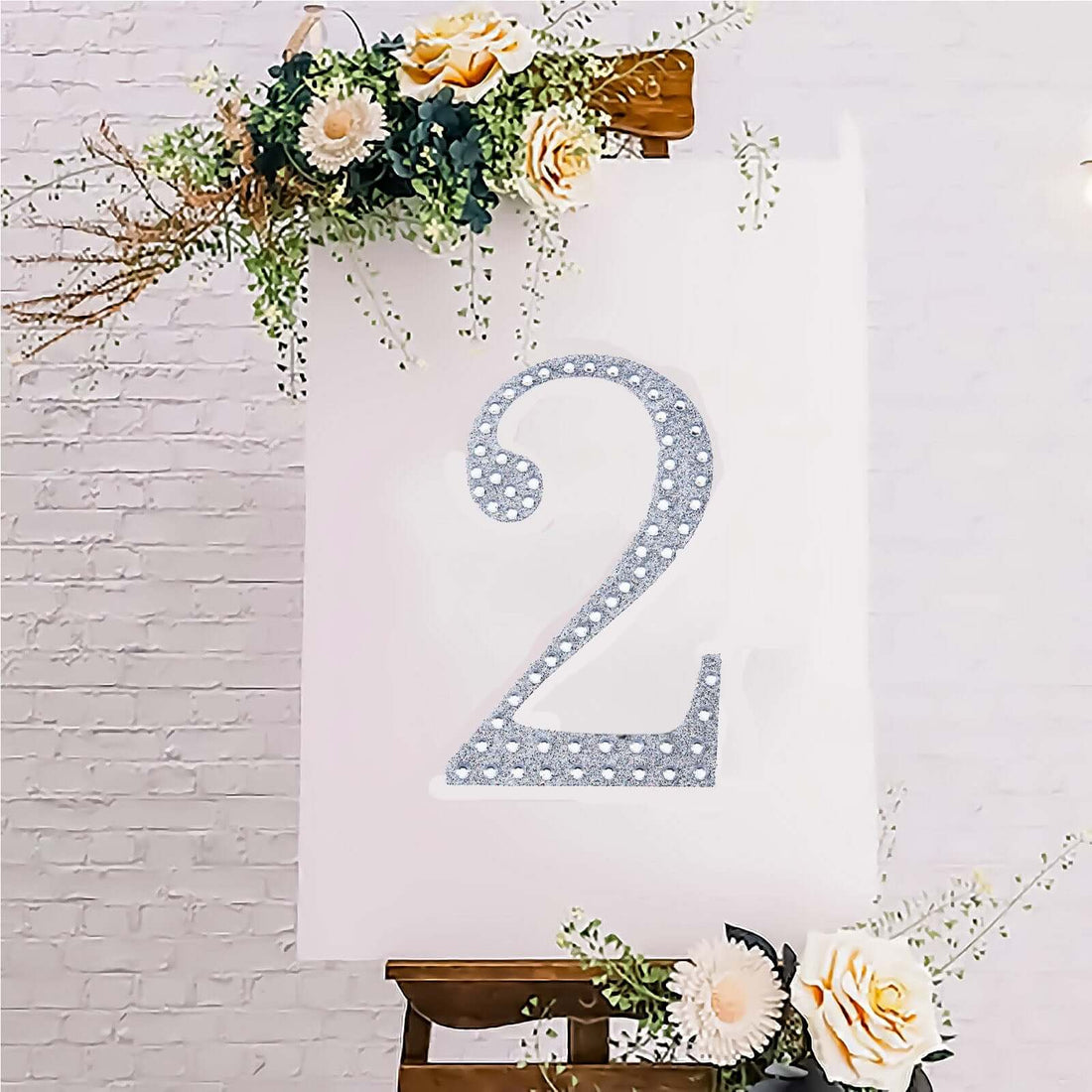 Decorative glitter number 2 on a canvas with floral accents.