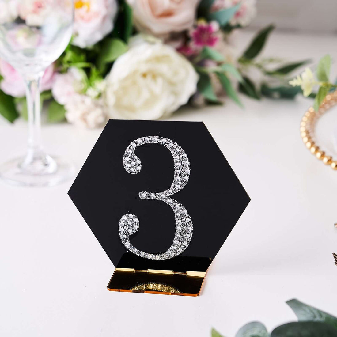 Black hexagon table number 3 with rhinestones on a decorative table setting.