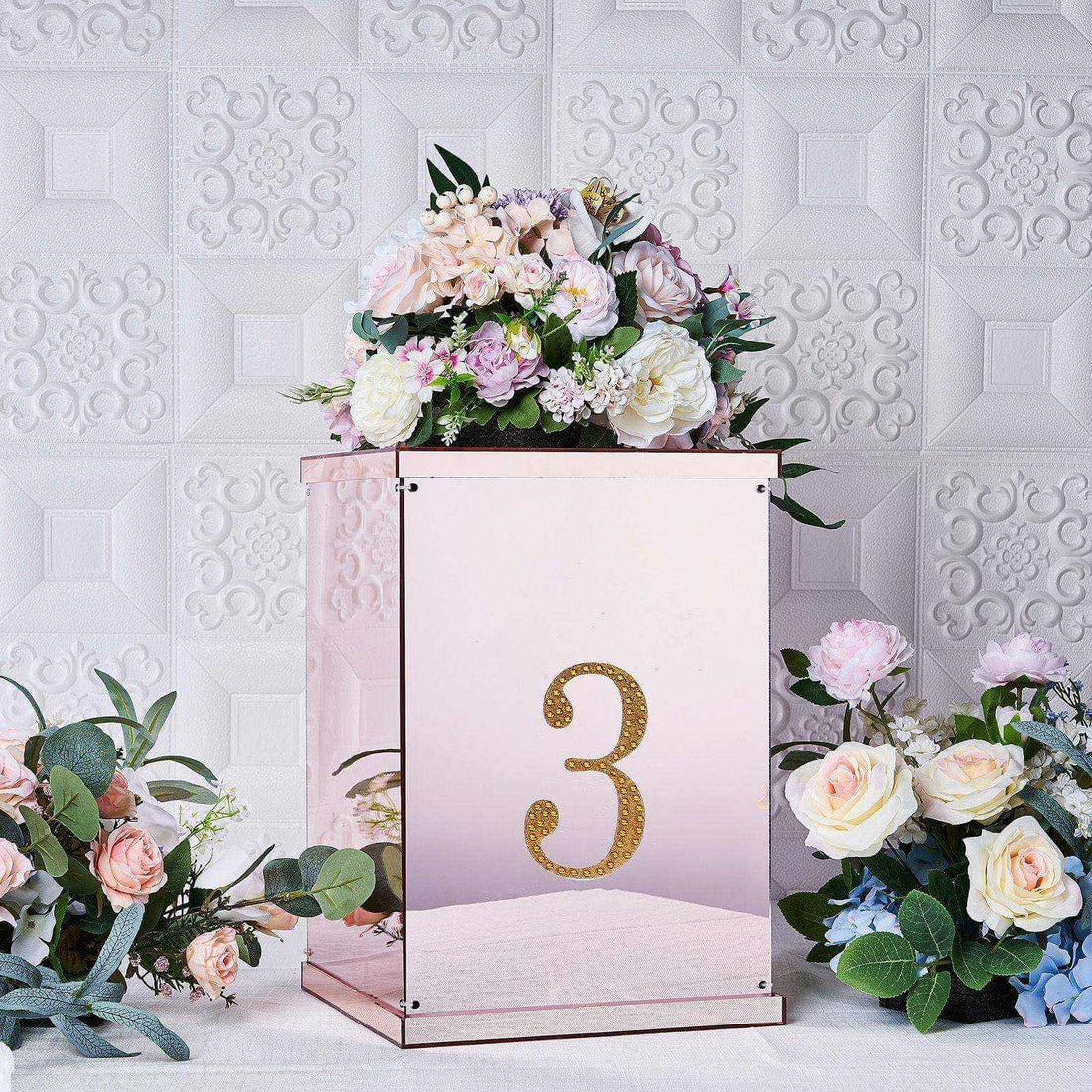 Rose gold table number holder with floral arrangement and number 3.