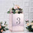 Rose gold floral centerpiece with number 3, surrounded by flowers.