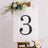 Decorative number three on an easel with floral accents.