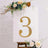 Gold glitter number three on a white backdrop with floral accents.