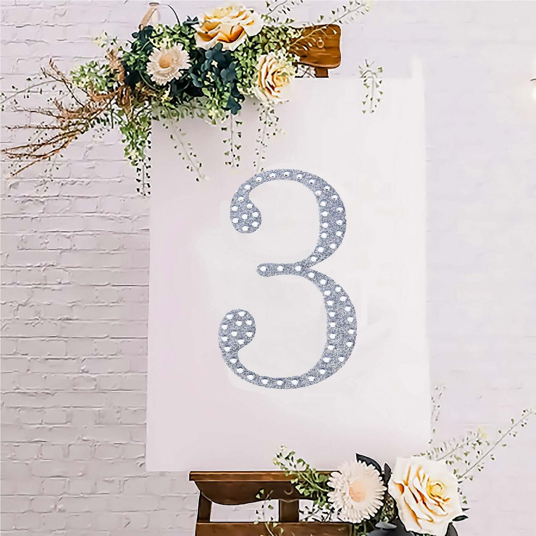 Decorative floral number 3 on a canvas backdrop with flowers.