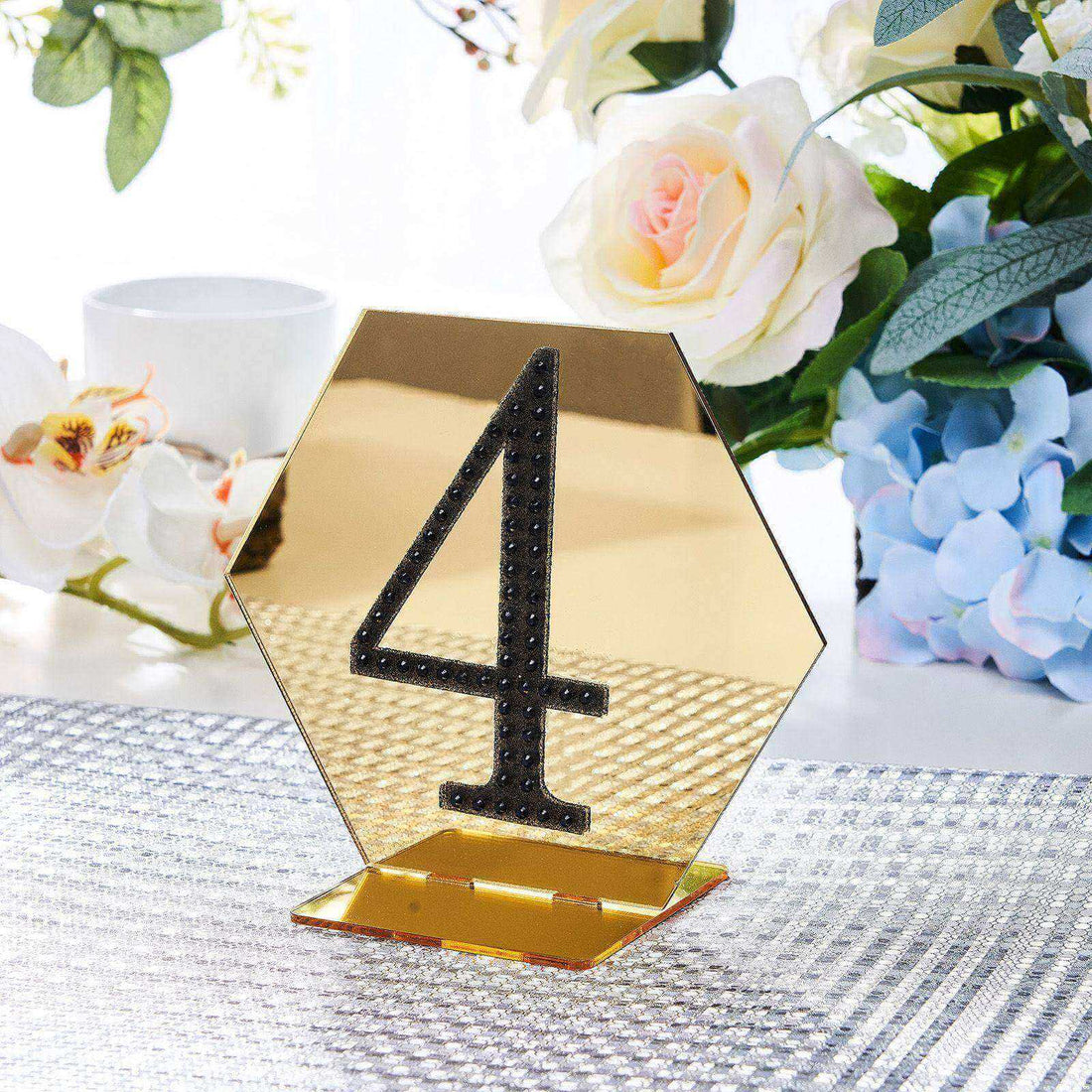 Gold hexagonal table number 4 holder with decorative rhinestones.