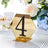 Gold hexagonal table number 4 holder with decorative rhinestones.