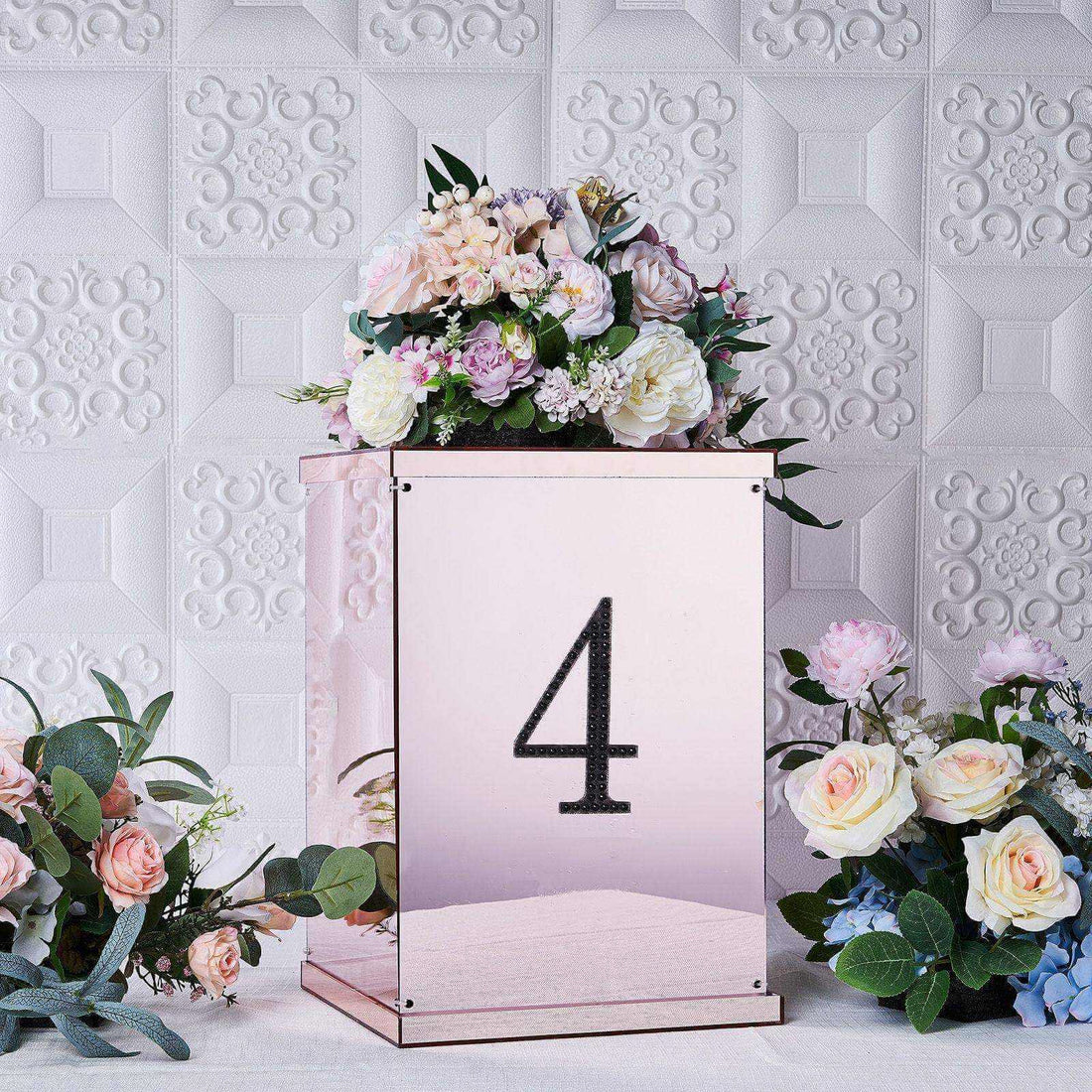 Floral arrangement in a mirrored box with the number 4 on a decorative backdrop.