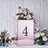 Floral arrangement in a mirrored box with the number 4 on a decorative backdrop.