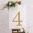 Gold marquee number 4 with floral accents on a display board.