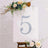 Decorative table number five with floral accents on a display board.