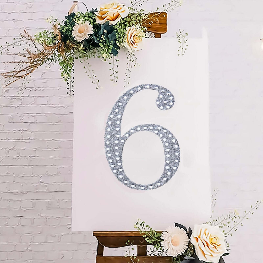 Decorative silver number 6 with floral accents on a white background.