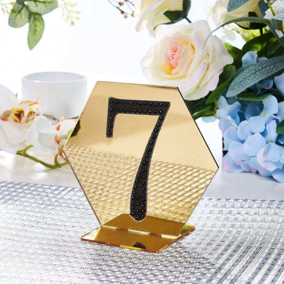 Gold hexagonal table number 7 stand with black accents on a table setting.