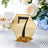 Gold hexagonal table number 7 stand with black accents on a table setting.
