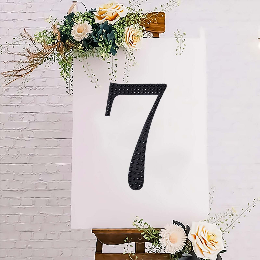 Black number 7 on a decorative easel with flowers