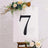 Black number 7 on a decorative easel with flowers