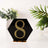Black hexagon table number 8 with yellow rhinestones on a plain background.